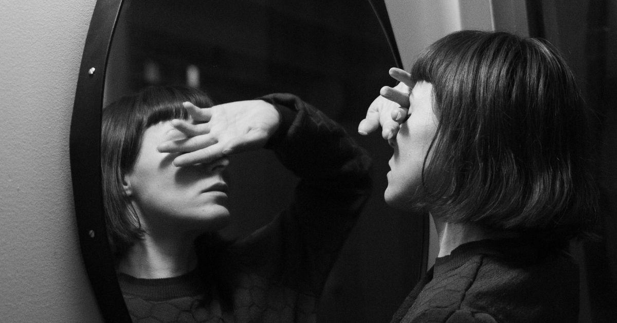 Woman-with-hand-over-her-eyes-in-front-of-a-mirror.jpg